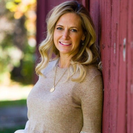 Natalie Schneider leans against a wooden wall